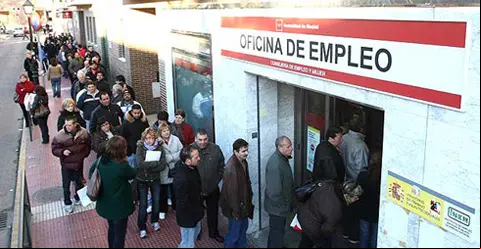 Un grupo de personas hacen cola a las puertas de la Oficina de Empleo
