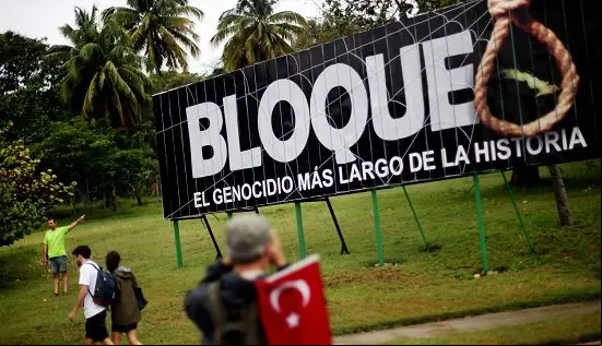 People march by a sign saying, "The embargo: the longest genocide in history," during the 1st of May Labor Day March - a call for people to march in of their local socialist government and the Cuban Revolution - in Havana, Cuba, on May 01, 2015. The commercial, financial and economic embargo enforced by the United States against Cuba went into effect in 1960, nearly two years after the deposition of the Fulgencio Batista dictatorship by the Cuban Revolution, and just after Cuba nationalized American-owned Cuban properties without remuneration to the States. The embargo at first did not apply to food and medicine, but was quickly broadened to nearly all U.S. exports. Proponents of the embargo cite repeated human rights violations in the country and the appropriated property as reasons to uphold it. Critics define the embargo as too harsh; the UN General Assembly has ed a resolution each year since 1992 criticizing its ongoing impact, citing it to be in violation of the Charter of the UN and international law. In December of 2014, U.S. President Barack Obama signaled an openness in thawing of U.S.-Cuban relations, which started with diplomatic talks and transitioned to the removal of Cuba from the U.S. list of state sponsors of terrorism in May of this year.