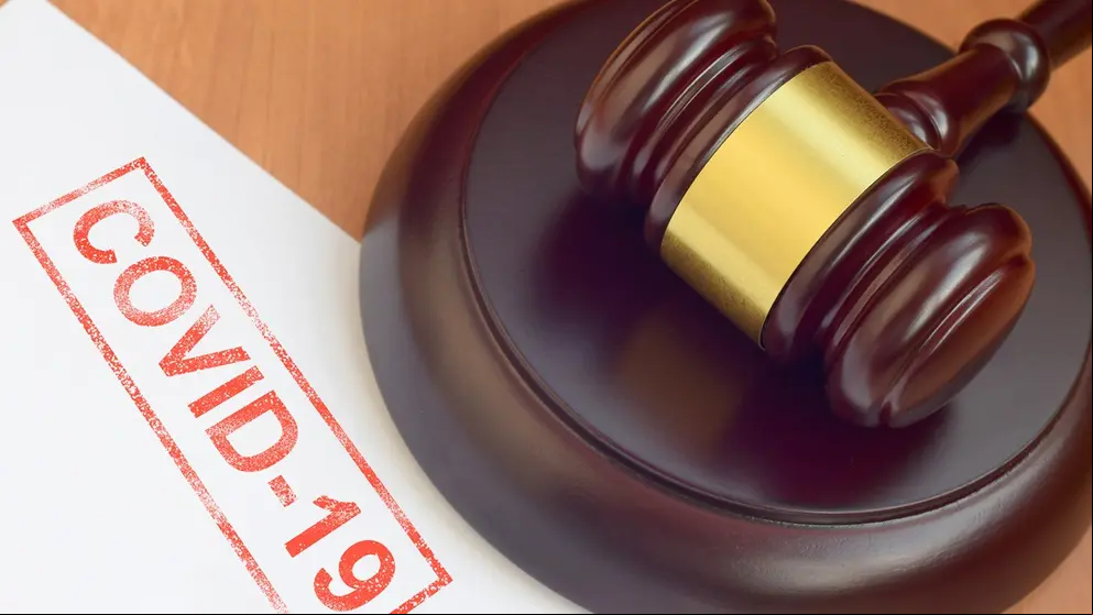 Justice mallet and blank document with Covid-19 red stamp close up
