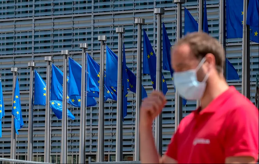 Brussels (Belgium), 25/05/2020.- A man wearing a face mask walks in front of the European Commission flags at the Berlaymont building headquarters in Brussels, Belgium, 25 May 2020. Countries around the world are gradually easing COVID-19 lockdown restrictions in an effort to restart the economy and help people in their daily routines. (Bélgica, Bruselas) EFE/EPA/OLIVIER HOSLET