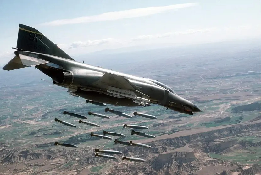 An air-to-air right side view of an 81st Tactical Fighter Squadron F-4E Phantom II aircraft releasing 18 Mark-82 500-pound bombs over the Bardenas Reales Gunnery Range. (U.S. Air Force photo by Staff Sgt. David Nolan)