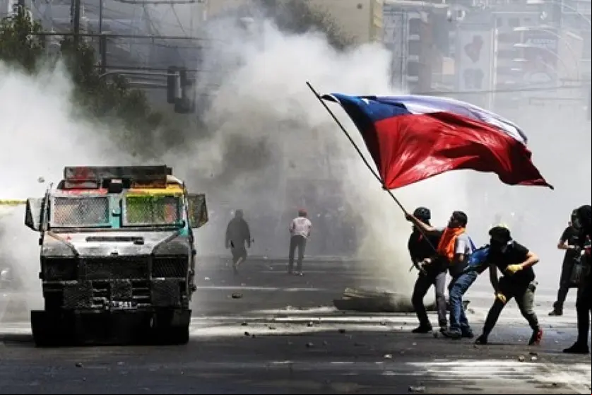Manifestantes ondean una bandera chilena durante una protesta contra el Gobierno en las manifestaciones del 'estallido social' en octubre de 2019.